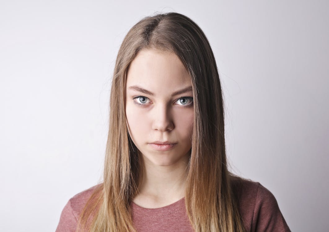 Selfie taken at eye level, shoulders-up framing, face looking straight into camera — crisp focus, evenly lit